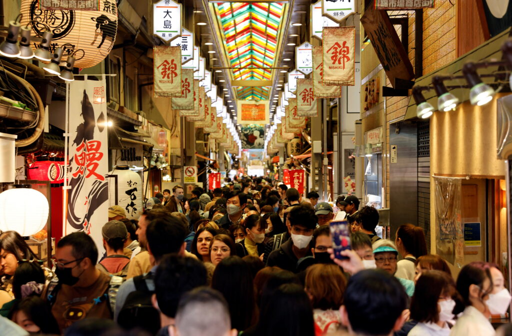 A crowd of tourists walk at Nishiki Market in Kyoto
